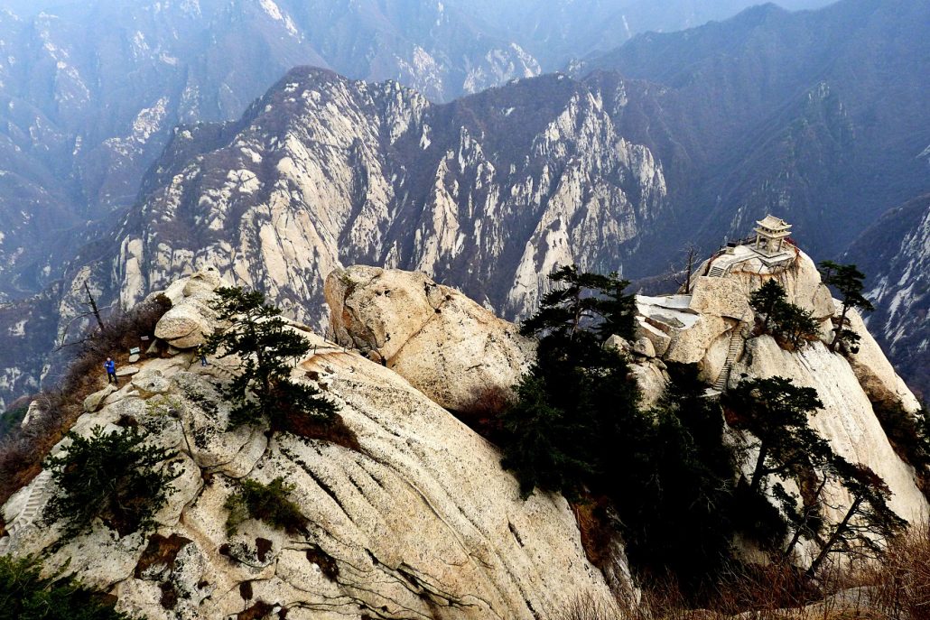 Rocky ridge of Mount Hua with pine trees and a small pavilion perched on a granite outcrop.