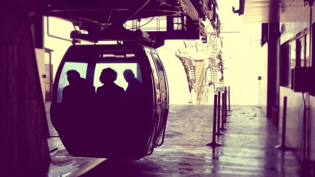 Silhouettes of passengers in a cable car gondola arriving at a station on Mount Hua.