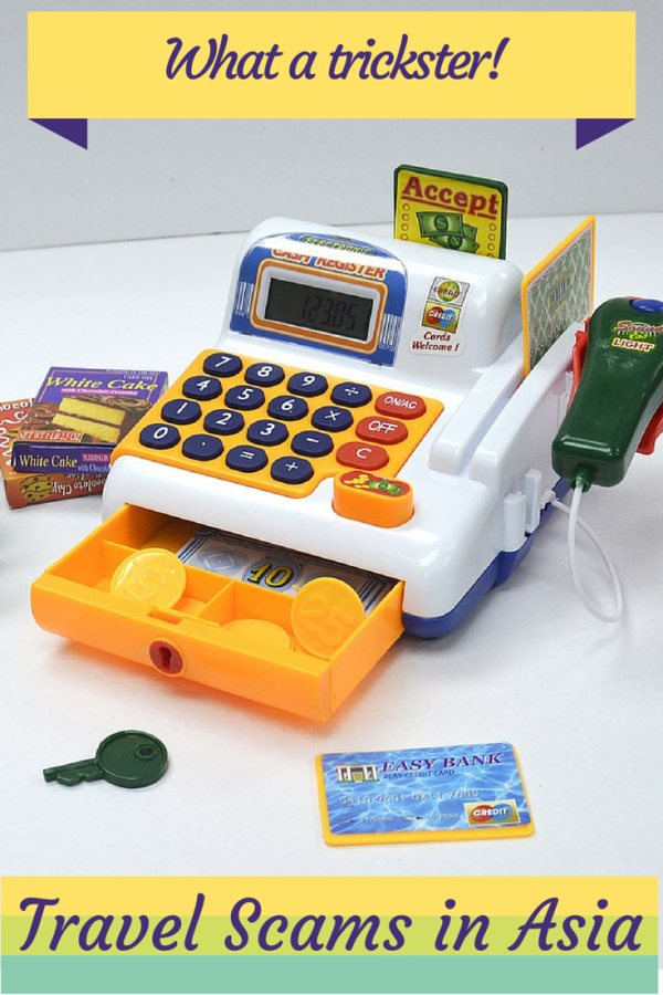 Pinterest graphic titled 'What a trickster! Travel Scams in Asia' over a toy cash register with fake money and a credit card.