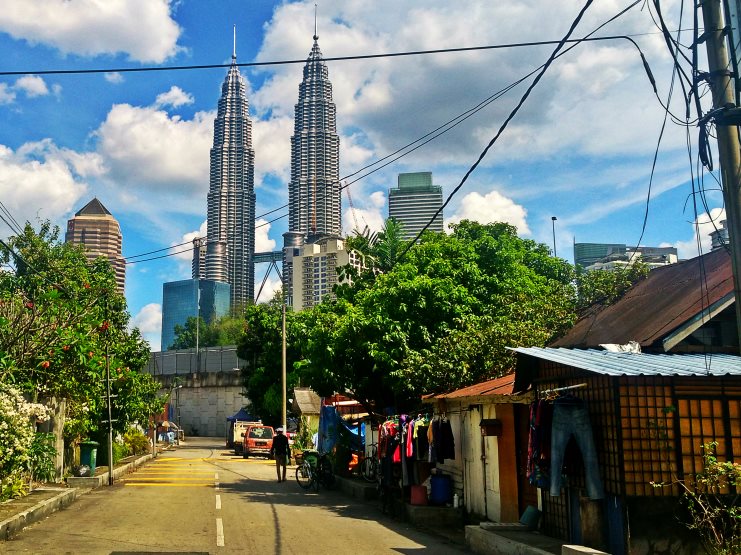 The Petronas Twin Towers rising above a quiet Kuala Lumpur backstreet.