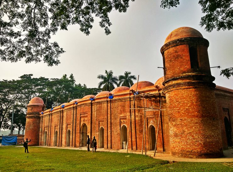 The red-brick Sixty Dome Mosque with domed towers and arched entrances in Bagerhat, Bangladesh.