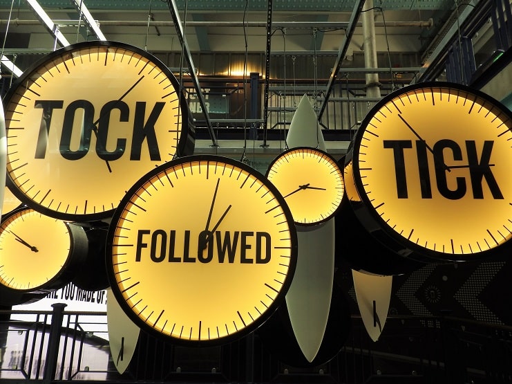 Illuminated clock faces reading Tick, Tock and Followed hang in the Titanic museum, Belfast.