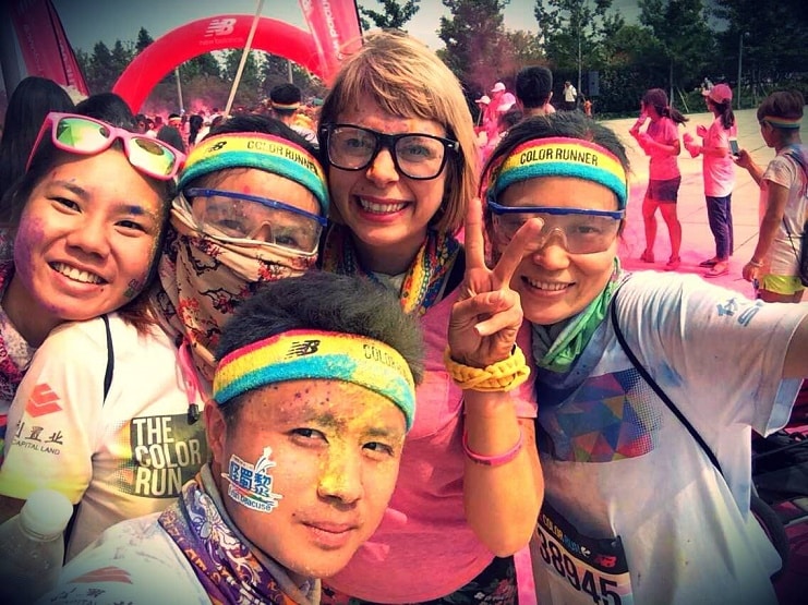 Alice takes a selfie with four paint-covered runners at a Color Run event.