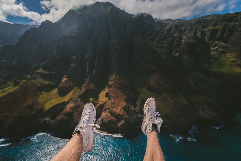 Paragliding above the sea and mountains with a view of your feet